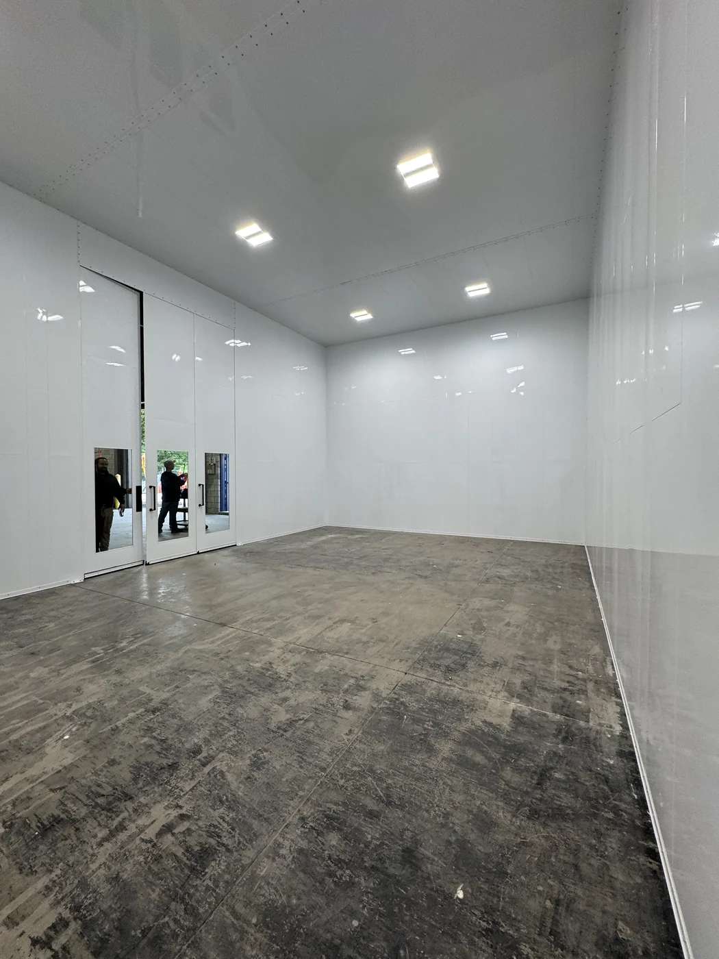 Large finished room with integrated ceiling lights and glazed entry doors