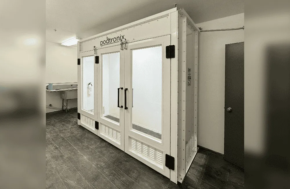 Three-quarter view showing compact single-skin enclosure, self-closing door hardware, and fire extinguisher bracket