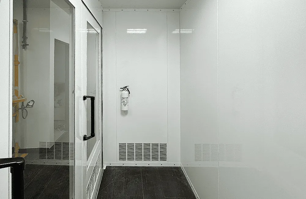 Interior – flush panel walls, lower-plenum louvered exhaust, and fire extinguisher station